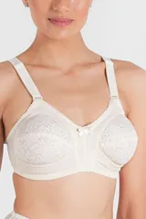 Soutien reductor sin aro color blanco, con copas reforzadas y detalle de puntilla. Confeccionado con tela que contiene fibra LYCRA®. Breteles anchos elásticos regulables.