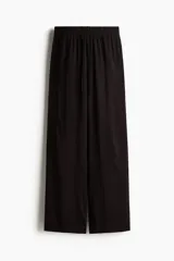 Pantalón de viscosa liviana color negro, de tiro alto y corte amplio, con elástico y cordón ajustable en la cintura.