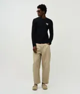 Pantalón chino de sarga color beige, con pinzas frontales, corte recto y largo completo. Cuenta con bolsillos laterales y traseros, cierre frontal con botón y cierre.