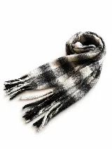 Bufanda de tejido suave con diseño a cuadros en tonos blanco, gris y negro, con flecos en los extremos.