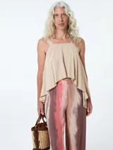 Top color beige con breteles anchos y corte asimétrico.