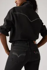 Pantalón jean de corte bootcut, color negro con efecto gastado, tiro súper bajo y cierre frontal con botón y cremallera.