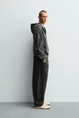 Pantalón jogger balloon fit de hombre, color negro con efecto lavado, confeccionado en algodón con interior afelpado. Cuenta con cintura elástica, bolsillos laterales y detalle de bolsillos traseros.