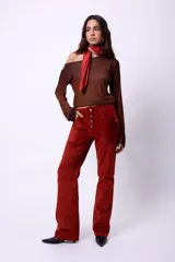 Pantalón de tiro alto confeccionado en pana color óxido. Presenta cierre frontal con botonadura metálica, bolsillos plaqué laterales y diseño de pierna flare.