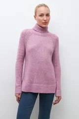 Sweater gris melange de tejido buclé con cuello alto y mangas largas.