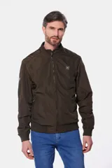 Campera liviana de color verde grisáceo, con cierre frontal, cuello alto y puños elásticos. Presenta un pequeño parche con logo en el pecho.