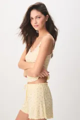 Pijama corto de color azul marino con pequeño estampado floral blanco, compuesto por una musculosa con detalles de encaje en el escote y un short con cordón ajustable en la cintura.