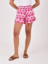 Short negro de tiro alto con cintura fruncida elástica y cordón ajustable con borla rosa. Presenta un ruedo con volado.