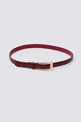 Cinturón fino de cuero con textura efecto cocodrilo en color bordó, con hebilla metálica dorada de diseño geométrico.