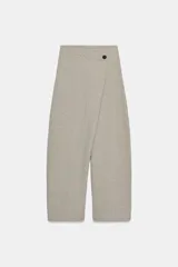 Pantalón de tiro alto con diseño cruzado frontal y cierre de botón. Presenta pierna ancha y cintura elástica, confeccionado en tejido de algodón.