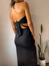 Vestido negro con escote halter y diseño cut-out en la cintura.