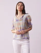 Blusa de gasa estampada con cuello a la base, escote en V plisado y lazo de ajuste. Delantera con detalles en puntilla y manga corta con puño fruncido.