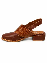 Zapato destalonado de cuero marrón con puntera cerrada, detalles de textura grabada en la capellada y tira ajustable con hebilla en el talón, con taco bajo y ancho.