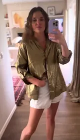 Camisa dorada metalizada de lino, corte holgado, con tajos laterales y espalda más larga.