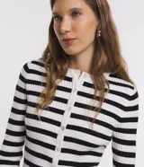 Cardigan de punto con diseño a rayas horizontales en blanco y negro, cuello redondo, manga larga y cierre frontal con botones.