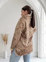 Sobrecamisa de pana color beige con estampado animal print, cuello camisero con solapa, cierre frontal con un botón, un bolsillo de parche en el pecho y puños y cuello con detalle de piel sintética.