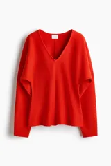 Remera de punto fino en color rojo con escote en V, cintura entallada y mangas dolman largas.
