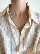 Collar corto de cuentas de piedra en tonos turquesa y celeste, con diseño de piedras facetadas y cuentas irregulares intercaladas.