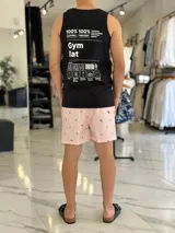 Musculosa blanca con estampado negro en la espalda con diseño tipográfico y gráfico inspirado en información nutricional humorística.