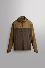 Chaqueta cortavientos Zara Athleticz de diseño bicolor en tonos marrón y tostado, con capucha, cierre frontal de cremallera y bolsillos funcionales.