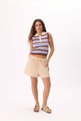 Top tejido de punto a rayas horizontales en tonos celeste, azul y blanco, con cuello tipo polo y cierre de botones.