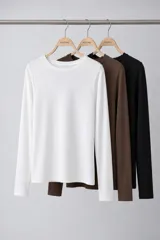 Pack de tres remeras de manga larga con cuello redondo, confeccionadas en algodón. El set incluye una remera blanca, una marrón chocolate y una negra.