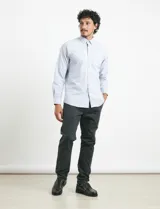 Pantalón de corte clásico confeccionado en sarga de algodón con elastano. Presenta bolsillos delanteros inclinados y bolsillos traseros de ribete con botón.