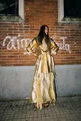 Tapado marrón de cuero con corte a la rodilla, mangas largas y aberturas laterales.