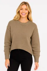 Sweater de punto canalé color beige, con cuello redondo a la base, mangas largas y diseño holgado de corte ligeramente cropped.