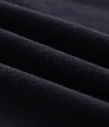 Polo de manga corta confeccionada en algodón de media malla, color negro con detalles en blanco en el cuello y los bordes de las mangas. Presenta cuello polo tradicional y cierre frontal con botones.