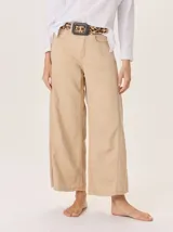 Pantalón ancho color beige, de corte holgado y tiro alto, con costuras visibles en el frente de las piernas.