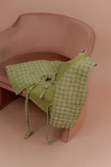 Chaleco verde claro con diseño acolchado y estampado a cuadros, sin mangas y con tiras para anudar en el frente.