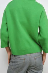 Jersey de punto liso confeccionado en lana 100%, con cuello redondo y mangas que llegan por debajo del codo.