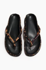 Chancletas planas con estampado de leopardo, tiras finas de dedo y plantilla preformada con acabado de pelo.