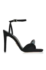 Sandalia de tacón alto color amarillo con pulsera al tobillo y detalle de moño con strass en la capellada.