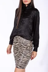 Camisa negra de lamé con cuello alto y mangas largas.