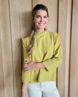 Blusa color verde oliva con cuello mao y mangas 3/4 con volados en los hombros.