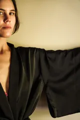 Kimono de seda negra con lazo ajustable en la cintura, mangas amplias y cuello solapa.