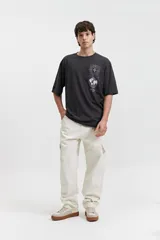 Jean cargo negro de tiro medio, con pasacinto, bolsillos laterales y bolsillos cargo con solapa en los muslos.