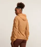 Campera deportiva femenina tipo parka, color ocre, confeccionada en poliamida y poliéster. Tiene cuello con capucha, mangas largas con puños elásticos, cierre frontal con cremallera y cordón ajustable en la cintura.