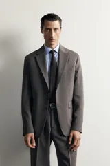 Blazer regular fit de Zara, confeccionada en tejido gris con mezcla de lana, con solapas de muesca, cierre de botonadura frontal y bolsillos con solapa en la cadera.