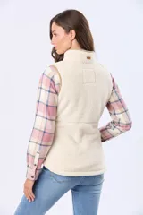 Chaleco de tejido sherpa color beige, con cuello alto y detalles en eco cuero. Diseño sin mangas que proporciona abrigo al torso manteniendo la libertad de movimiento.