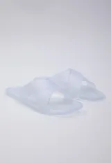 Sandalia chata de goma semi transparente color gris, con doble tira entrelazada sobre el empeine.