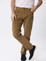 Pantalon de pana color tostado, de corte regular fit, con cinco bolsillos clásicos, cierre de botón y cremallera.