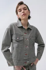 Campera de denim 100% algodón a rayas verticales en tonos grisáceos y azules. Cuenta con cuello camisero, cierre frontal con botones plateados y cuatro bolsillos frontales con botón.