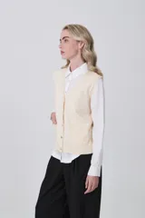 Chaleco de punto gris con escote en V, cierre frontal de botones y dos bolsillos delanteros con terminación acanalada.