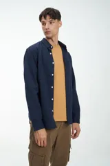 Camisa de manga larga azul confeccionada en tela 100% algodón. Bolsillo en pecho y botones personalizados. Calce clásico. Tela simil paño.