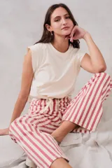 Pantalón de jean de corte recto, tiro medio, con estampado a rayas verticales rojas y crudas y cierre frontal con botones.