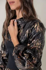 Blusa animal print en tonos negro y tostado, de satén de seda brillante. Presenta faja elastizada negra en la cintura y mangas abullonadas.