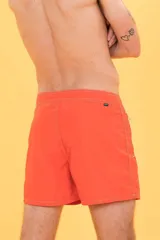 Short de baño naranja con cintura fija, bolsillo lateral con cierre, cordón bicolor y suspensor de malla fina.